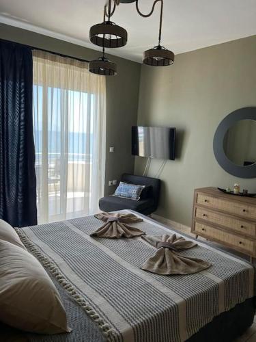 a bedroom with a bed with two towels on it at Marina's Boutique in Alexandroupoli