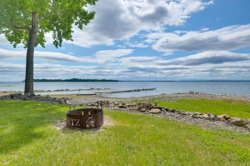 a picnic table in the grass next to the water at Lake Champlain Vacation Rental with Boat Dock! in Melville Landing