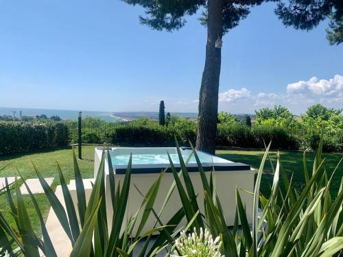 a swimming pool in a garden with plants at Tra gli Alberi e il Mare in Sirolo
