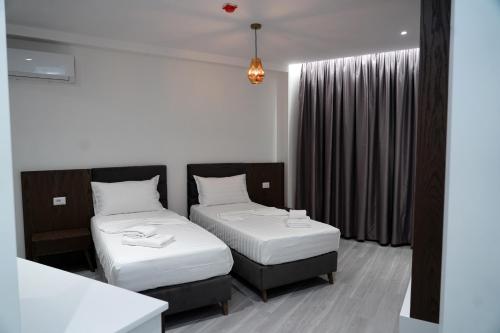 a hotel room with two beds and a window at The Honeycomb Boutique Hotel in Golem