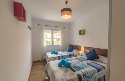 1 dormitorio con 2 camas y ventana en Magnificent villa: 2 private pools, BBQ, garden & parking. 13 per. In Padul, en Granada