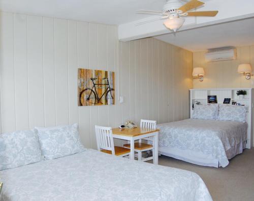a bedroom with two beds and a couch and a table at Ocean Vista Resort in Amagansett