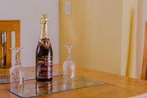 Una botella de champán y dos copas en una mesa. en Hotel Carnaval en Huejotzingo