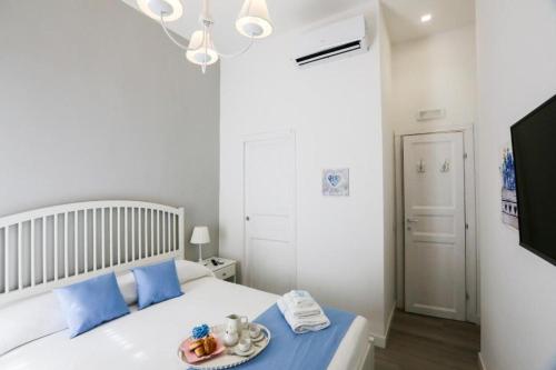 - une chambre avec un lit et une assiette de nourriture dans l'établissement Chiaia Bridge B&B, à Naples