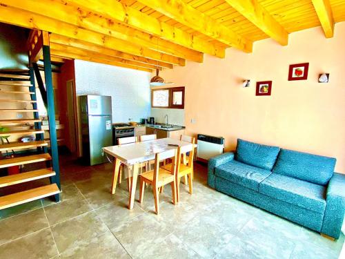 uma sala de estar com um sofá azul e uma mesa em Departamentos Tres Maitenes em Villa La Angostura