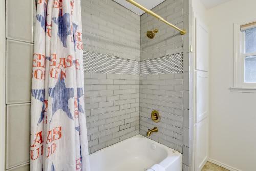 a bathroom with a tub and a shower curtain at Charming Home about 4 Mi to Fort Worth Stockyards! in River Oaks