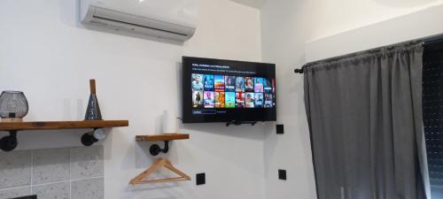 una TV a schermo piatto sulla parete di un bagno di au p'tit logis montlouisien a Montlouis-sur-Loire