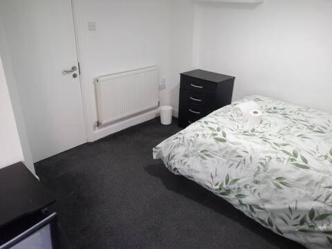 a bedroom with a bed and a black dresser and a bed sidx sidx sidx at Double-bed (G2) close to Burnley city centre in Burnley