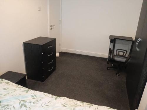 a bedroom with a bed and a dresser and a chair at Double-bed (G2) close to Burnley city centre in Burnley