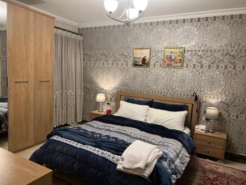 a bedroom with a bed with a blue comforter at Elegant duplex with pool frontAUC in Cairo