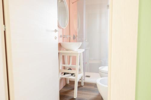 een badkamer met een wastafel, een toilet en een spiegel bij Le fanciulle di Pompei Suites in Pompei