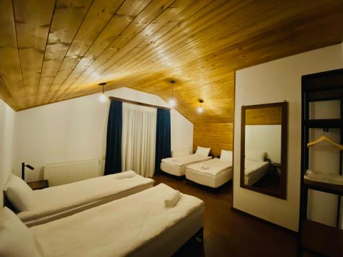 a hotel room with two beds and a mirror at Sno Inn Kazbegi in Stepantsminda