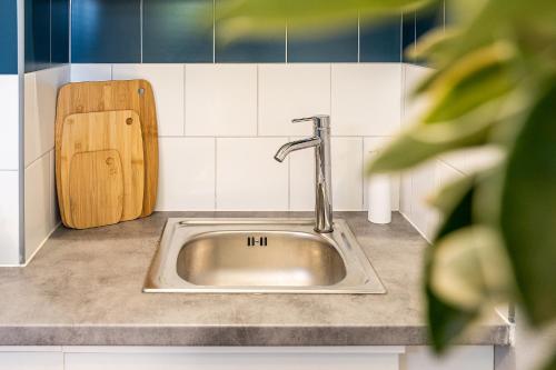 a sink in a kitchen with a wooden cutting board at Ti Colibri in Saint-Denis