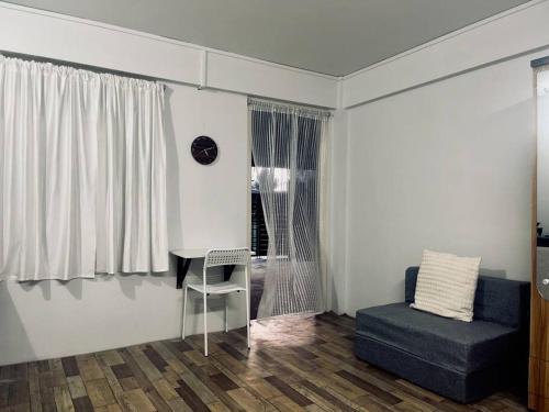 ein Wohnzimmer mit einem Schreibtisch, einem Stuhl und einem Fenster in der Unterkunft JoeLene's Studio Apartment in Lapalang, Shillong in Shillong