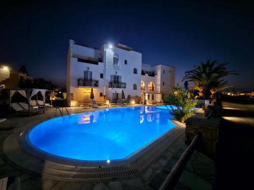 a swimming pool in front of a building at night at Sunlight Naxos in Naxos Chora