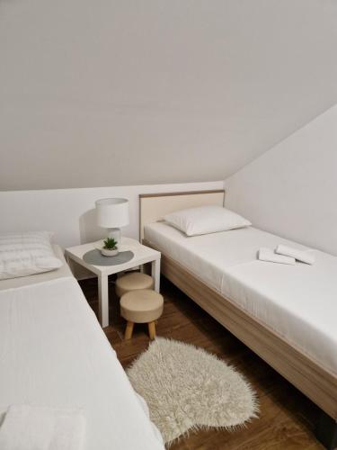 Un dormitorio con dos camas y una mesa con taburete. en Villa Tara, en Zadar