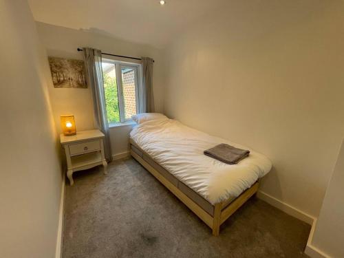 a small bedroom with a bed and a window at Tucked away house in Macclesfield in Macclesfield
