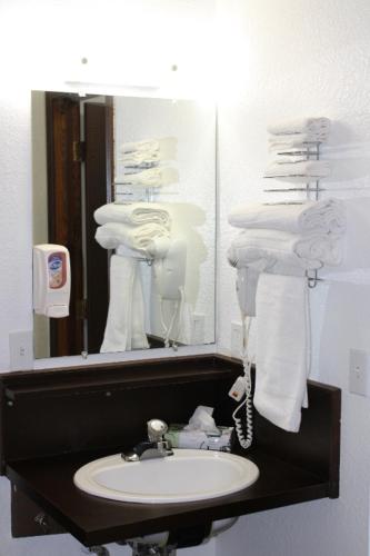 a bathroom with a sink and a mirror with towels at Aero Inn in Kalispell