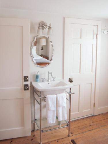 a bathroom with a sink and a mirror at The Historic General Stanton Inn in Charlestown