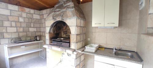 eine Küche mit einem Steinofen in der Wand in der Unterkunft R&A Apartmani Bečići in Becici