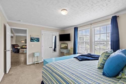 a bedroom with a bed with blue sheets and a window at Shell Landing Retreat in Beaufort