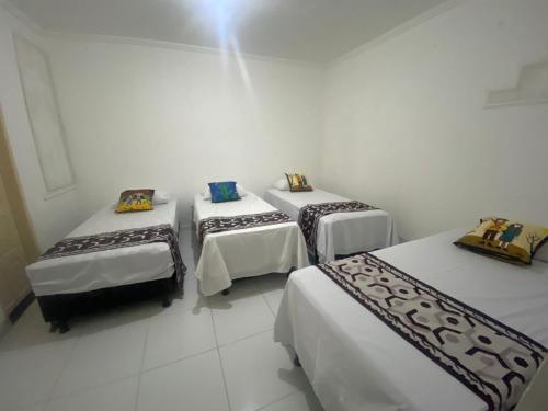 a group of three beds in a room at Temporada CG - Cantinho Nordestino in Campina Grande