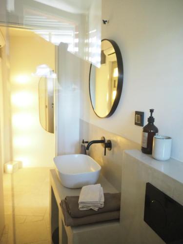 a white bathroom with a sink and a mirror at mi sestre – Studio Apartment Hvar Vrisnik in Jelsa