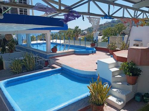a pool in a yard with two swimming pools at Hotel Corona Zihua in Zihuatanejo