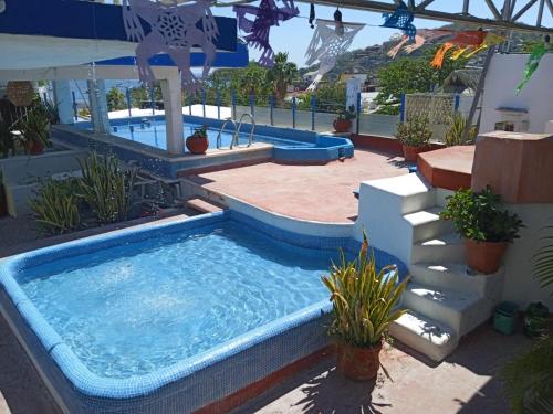 a pool in a backyard with a swimming pool at Hotel Corona Zihua in Zihuatanejo