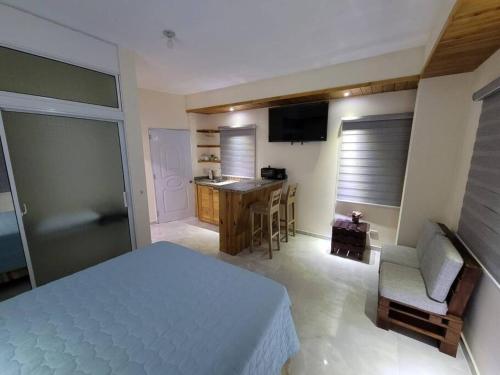 a bedroom with a bed and a kitchen with a table at Center Point Mono ambiente en Constanza in Constanza