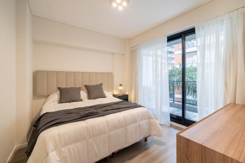 a bedroom with a bed and a large window at La Vie Suite Cañitas in Buenos Aires