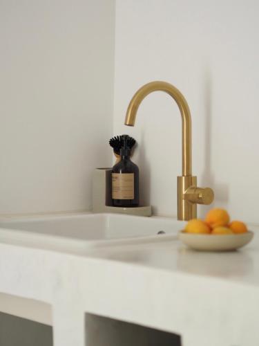 a kitchen counter with a sink and a bowl of oranges at mi sestre – Studio Apartment Hvar Vrisnik in Jelsa