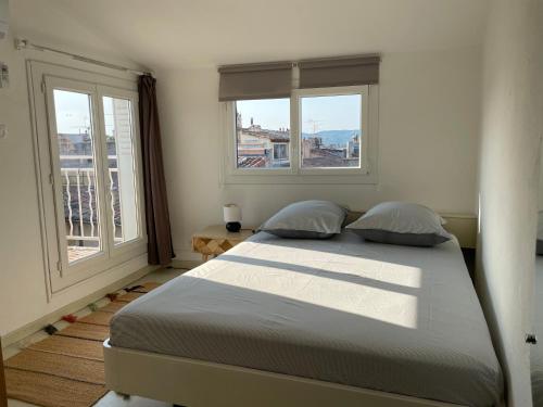 une chambre avec un grand lit avec deux fenêtres dans l'établissement 2 pièces climatisé en duplex avec terrasse, à Aix-en-Provence