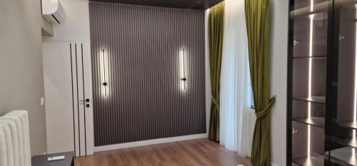 Habitación con armario y cortinas verdes. en Heart of Tirana Apartment en Tirana