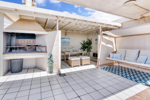 an outdoor patio with a grill and a table at Ático frente al mar, PataconaBlue, complejo vacacional in Valencia