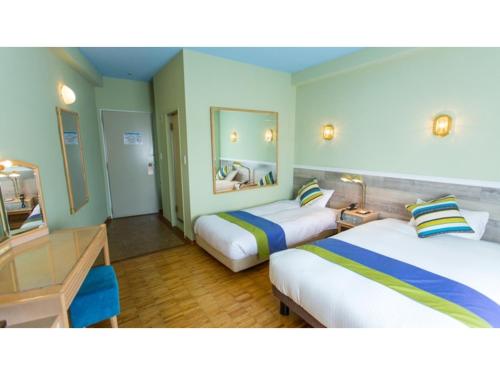 a hotel room with two beds and a desk at Hotel AreaOne Sakaiminato Marina - Vacation STAY 09680v in Sakaiminato