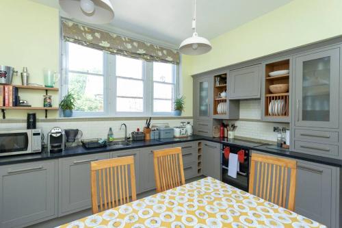 a kitchen with a table and two chairs in it at 3 The Old Schoolhouse: hot tub, log burner, parking, en-suite in Whitstable