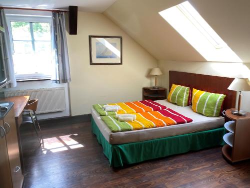 a bedroom with a bed with colorful pillows at Pension Unter der 250 jährigen Eiche - Lehde Zentrum in Kaupen