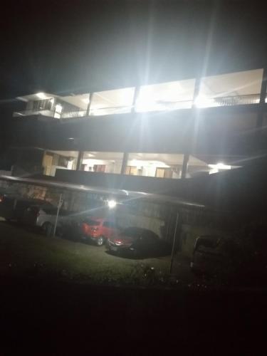 a building with cars parked in front of it at night at Sang Yoo Mountain View Tagaytay Bed and Breakfast - Taal Lake View in Tagaytay