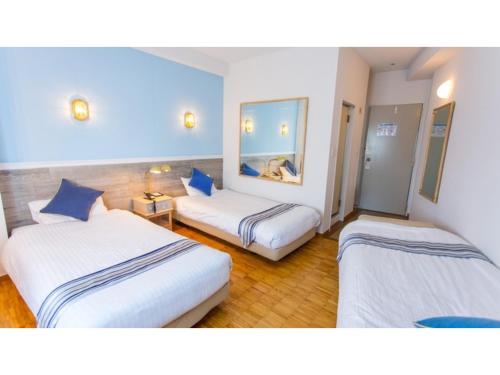 a hotel room with two beds and a mirror at Hotel AreaOne Sakaiminato Marina - Vacation STAY 09684v in Sakaiminato