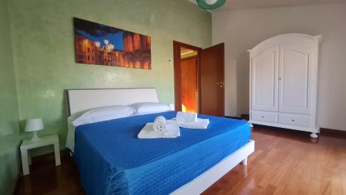 a bedroom with a blue bed with towels on it at Residenza Fiera Verona in in Verona