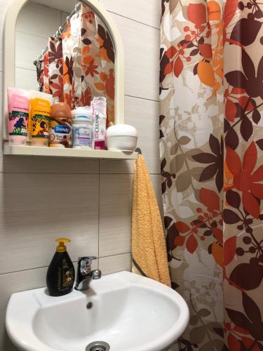 a bathroom with a sink and a shower curtain at House For Rent in Pristina