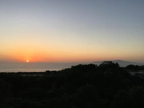a sunset with the sun setting over the ocean at Masaya Villa - Vacation STAY 23194v in Ito
