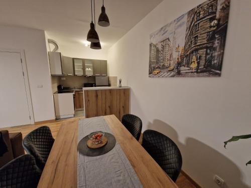 a dining room with a wooden table and chairs at Apartmani Djuric Center in Subotica