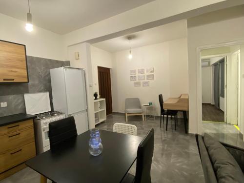 a kitchen and living room with a table and a refrigerator at Engomi Apartment in Yukarı Lakatamya