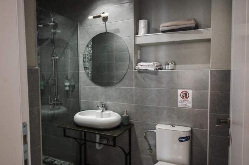a bathroom with a sink and a toilet and a mirror at MariaApartments in Bitola
