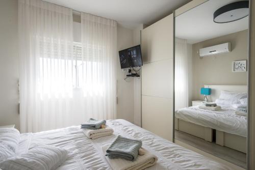 Un dormitorio blanco con una cama y un espejo. en Eshkol Housing Haifa - Luxury Villa Panoramic Sea View חיפה כרמל, en Haifa