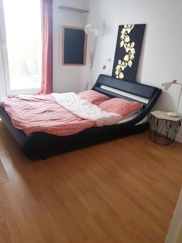 Cette chambre comprend un grand lit et du parquet. dans l'établissement Cosy bedroom in ideal apartment, à Villejuif
