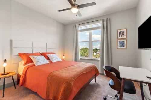 a bedroom with a bed and a desk and a window at Luxury Condo in Ybor City Tampa w/Pool access in Tampa