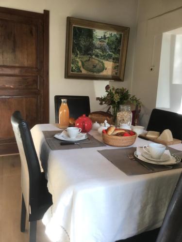 a table with a white table cloth and food on it at La ferme aux oiseaux B&B in Beaumont